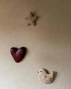Handgemaakt hartvormig 3D wandobject For Always van de LOve U serie van Studio Lamain in bordeauxrood met vogel en ster aan de muur.