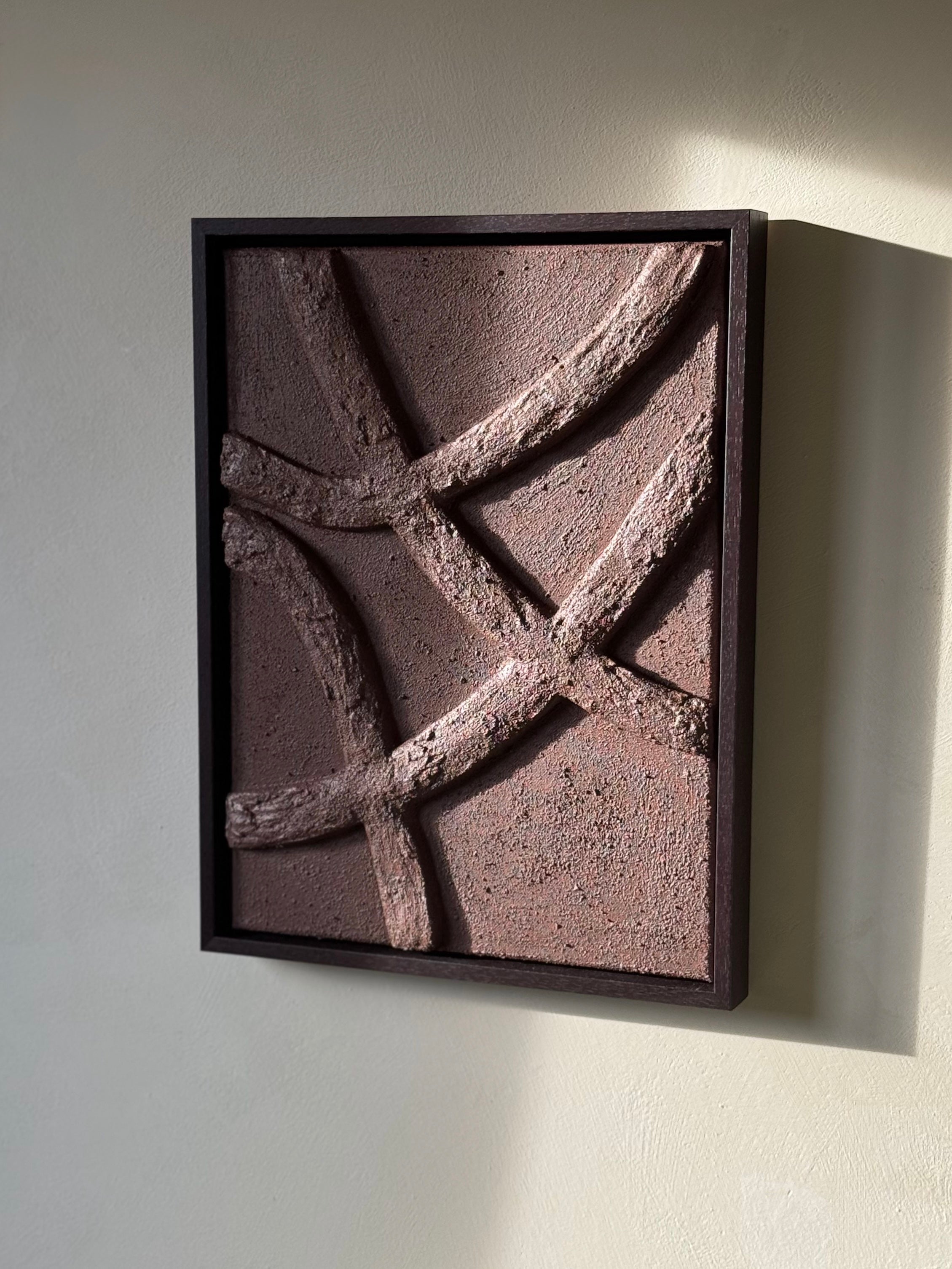 Chocoladebruin reliëf kunstwerk aan de muur met houten lijst, passend in een Japandi interieur, handgemaakt door Studio Lamain.