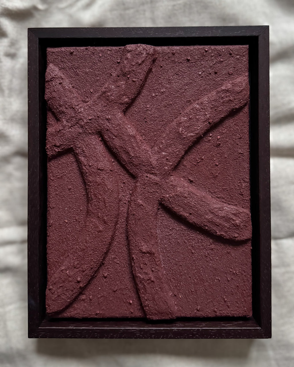 Abstract reliëf kunstwerk in bordeauxrood met houten lijst, organische lijnen en natuurlijk textuur, handgemaakt door Studio Lamain.