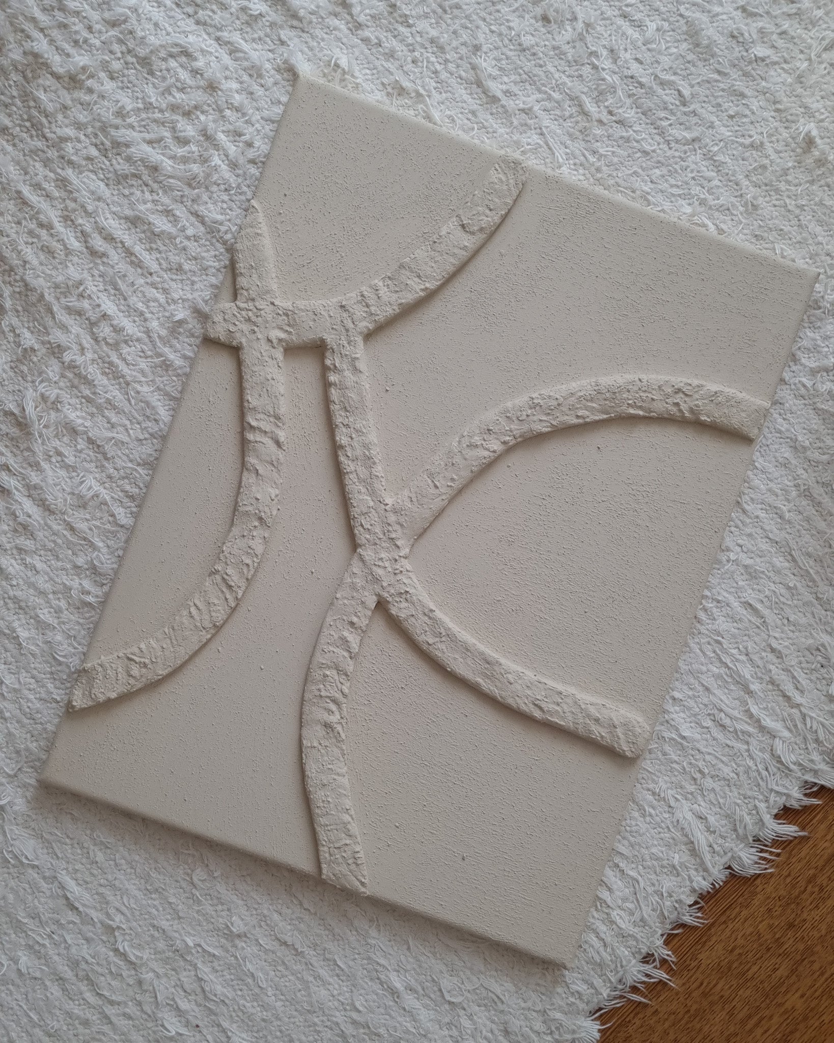 Abstract reliëf kunstwerk in beige met zachte organische lijnen en voelbare minerale structuur.