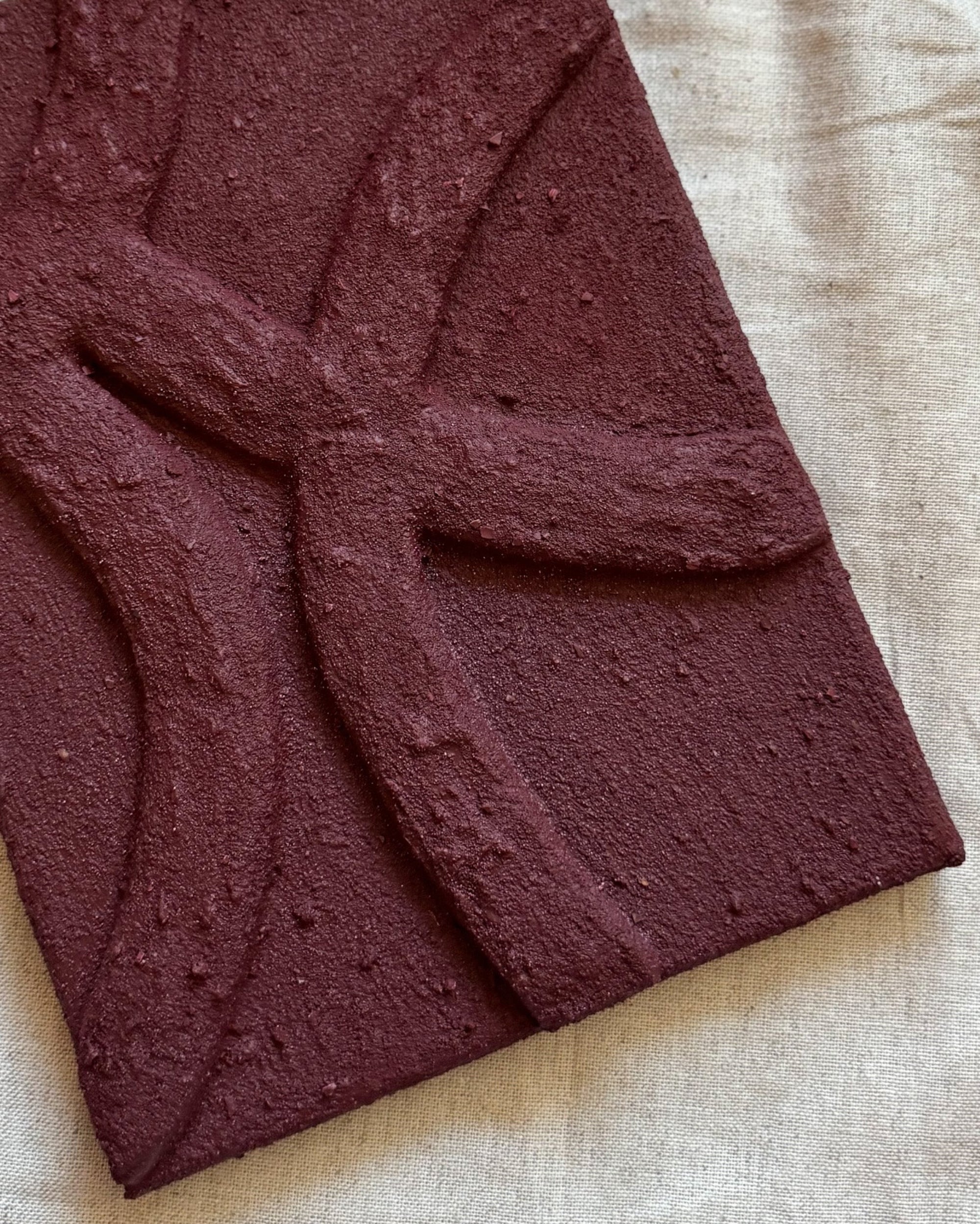 Detail van gelaagd abstract bordeauxrood kunstwerk in bordeauxrood met organische lijnen en voelbare structuur van Studio Lamain.