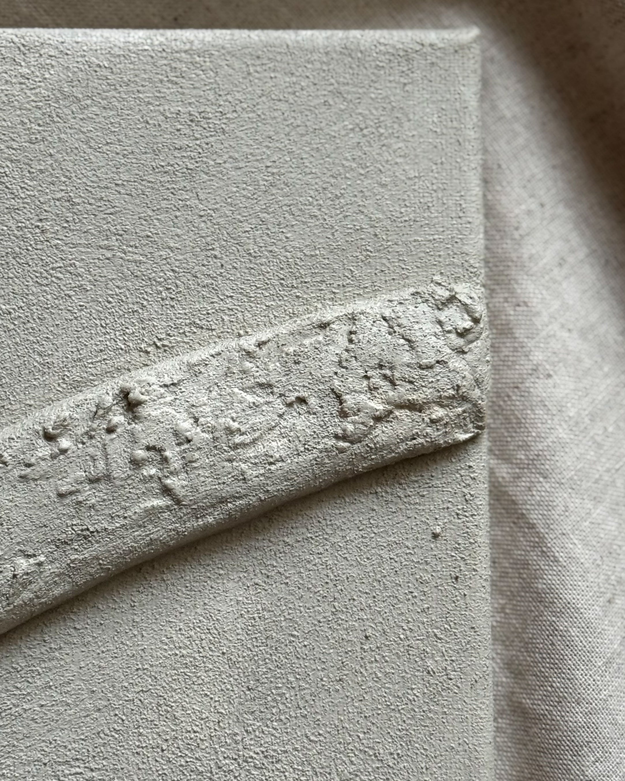 Mineraal ogende textuur van zandkleurig handgemaakt reliëf kunstwerk met organische lijnen.