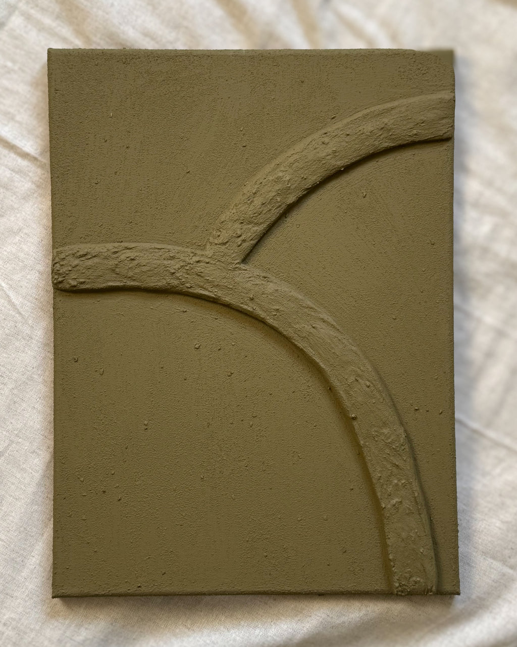 Abstract reliëf kunstwerk in olijfgroene kleur met organische lijnen en natuurlijke textuur, handgemaakt door Studio Lamain.