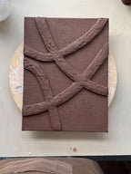Chocoladebruin reliëf kunstwerk, met organische vormen en natuurlijke textuur, handgemaakt door Studio Lamain.