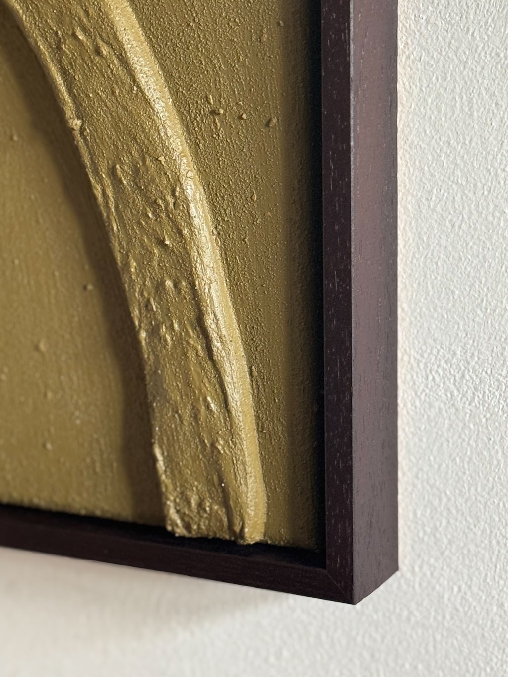Detail van olijfgroen reliëf kunstwerk met natuurlijke textuur en organische vorm, handgemaakt door Studio Lamain.