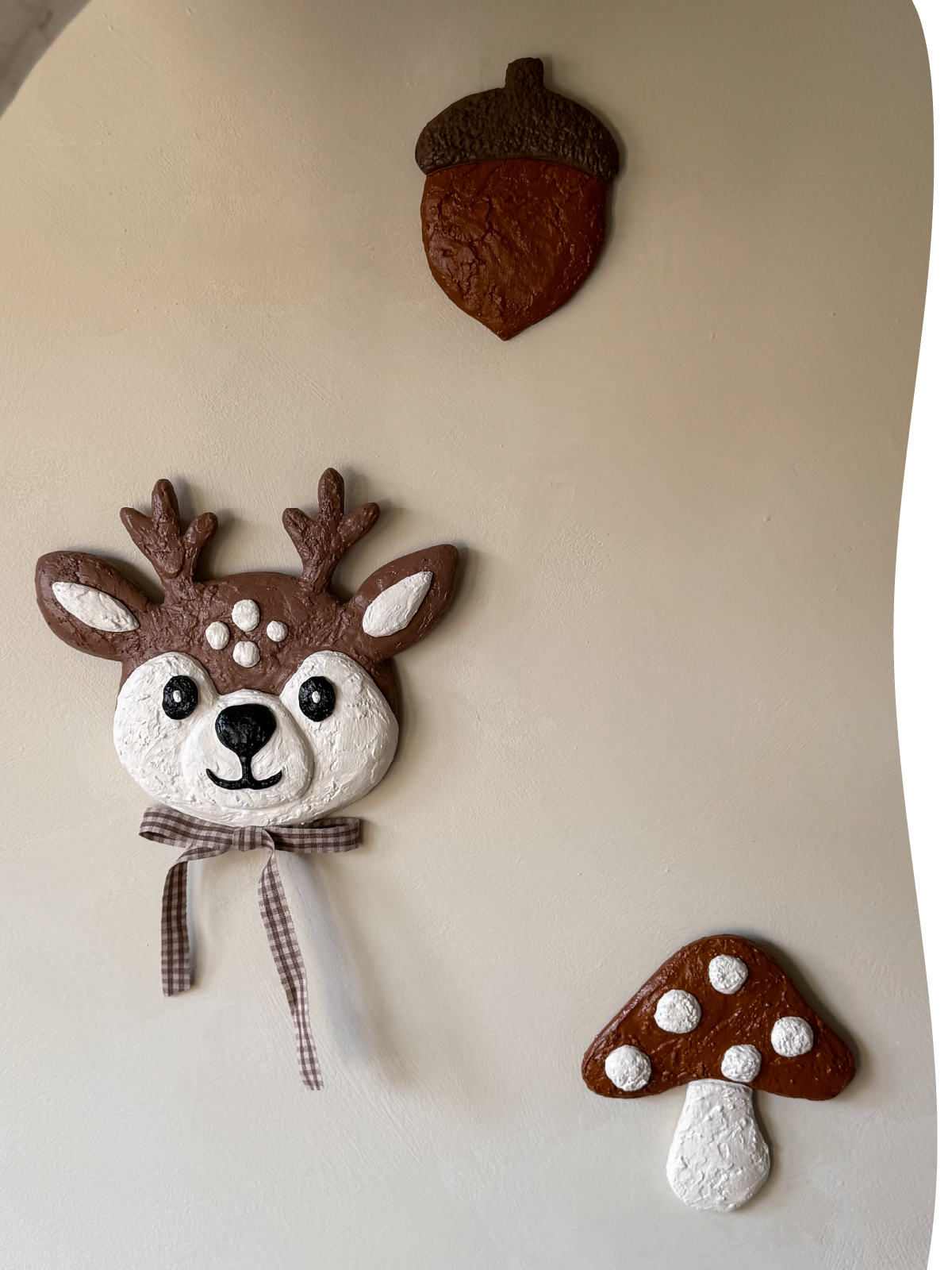 Handgemaakte 3D kunstobjecten voor de muur in de kinderkamer: een hertje, paddenstoel en eikel in zachte tinten.