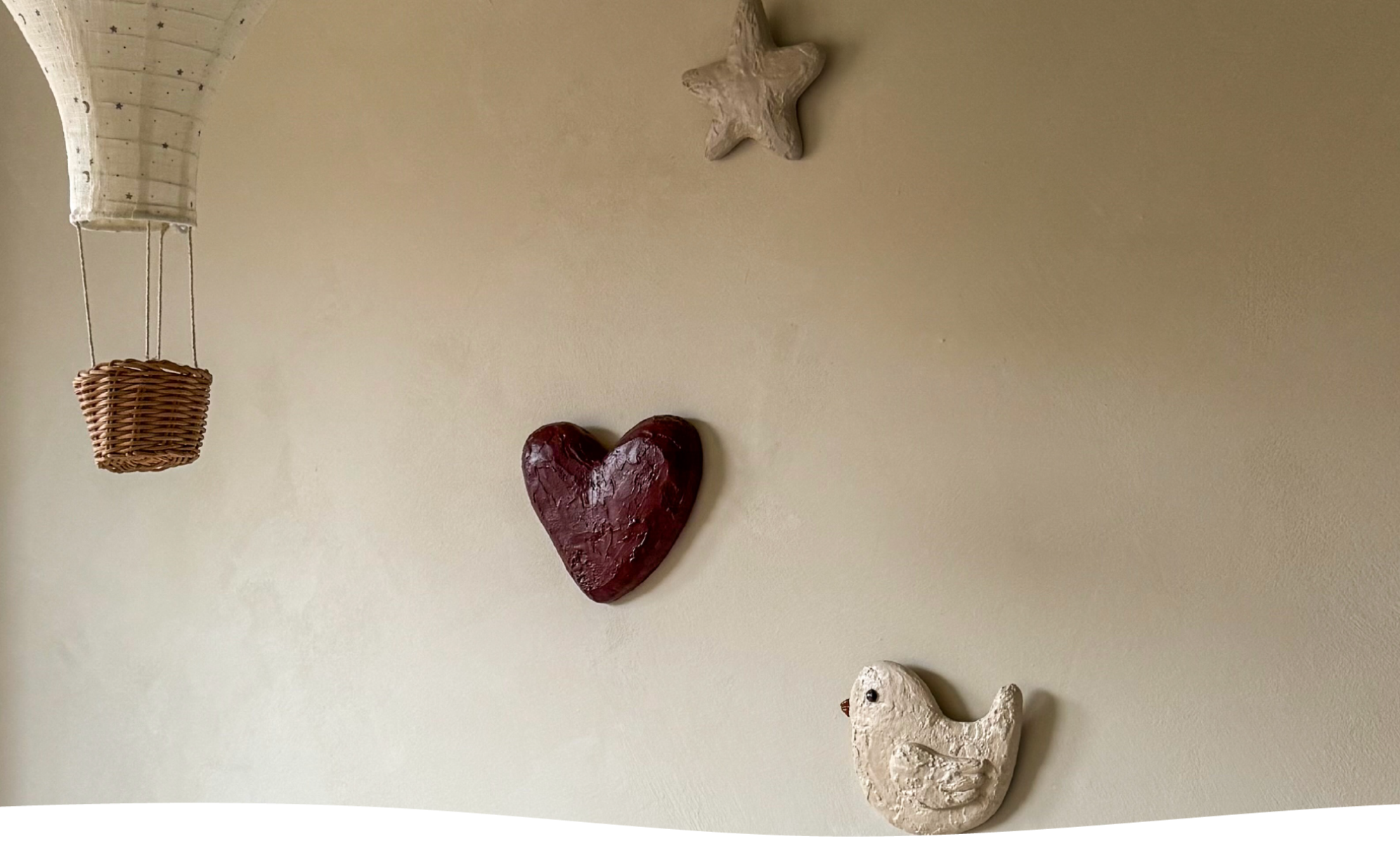 Handgemaakte wandobjecten voor de kinderkamer: een hart, ster en vogeltje in zachte tinten van Studio Lamain.