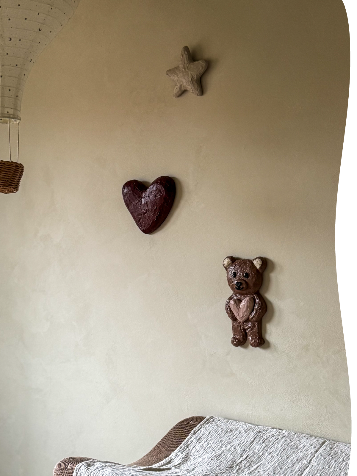 Drie driedimensionale wandobjecten van de Studio Lamain LOve U serie: een ster, hart en beer met hart in rustige kleuren aan de muur op een kinderkamer.