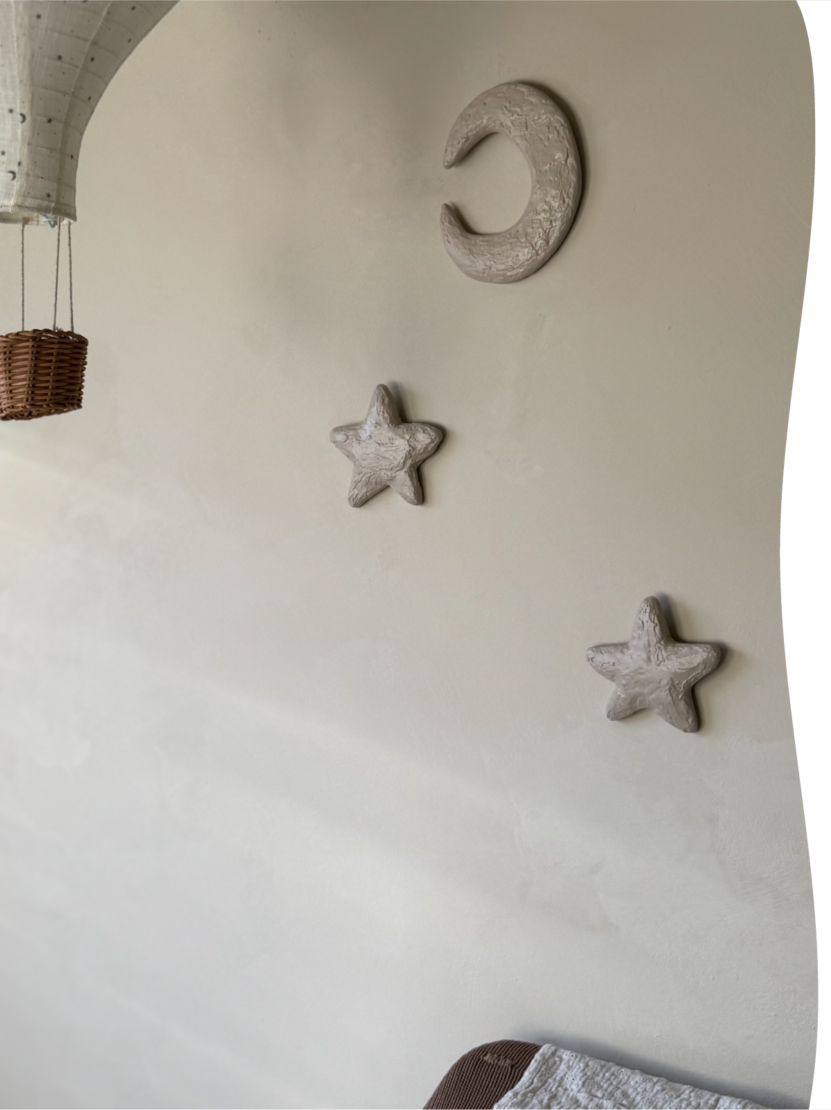 Drie driedimensionale To The Moon & the Stars wandobjecten van de Studio Lamain LOve U serie: twee sterren en een Lou maan in beige aan de muur op een kinderkamer.