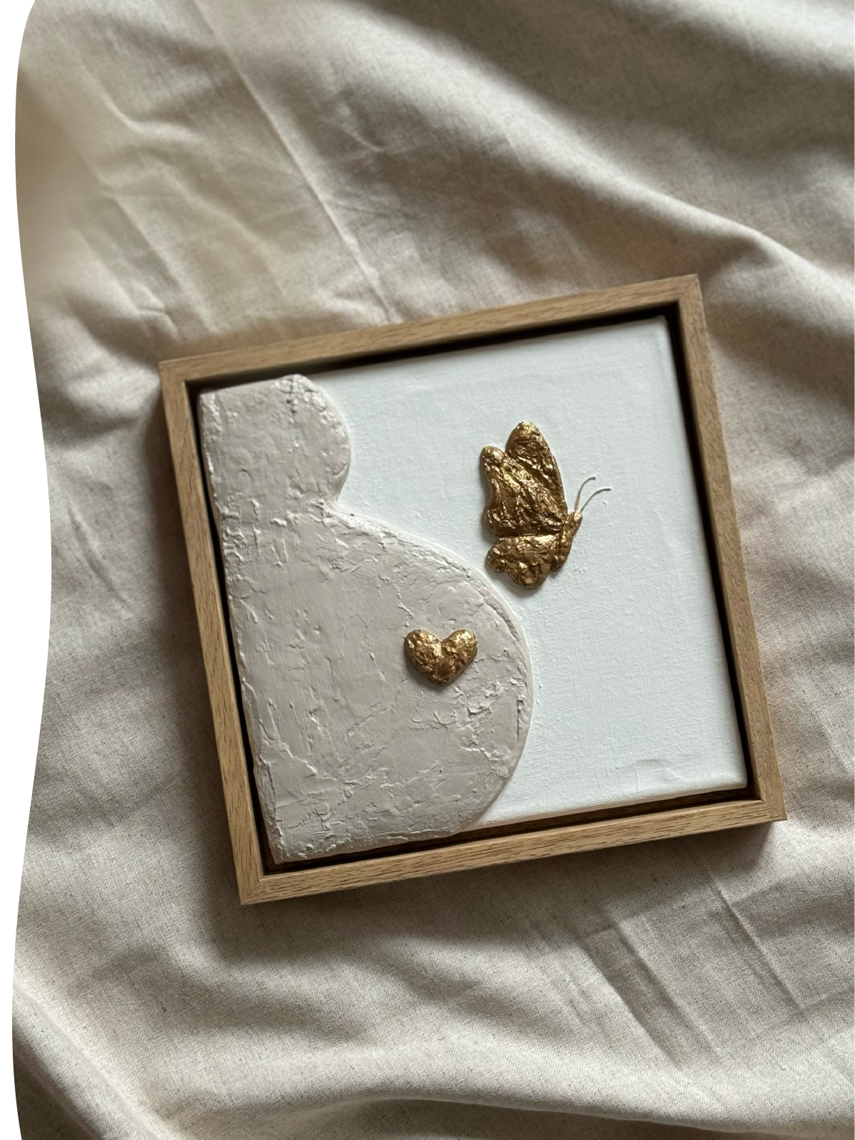 Een reliëfkunstwerk van een zwangere buik met hart en vlinder – persoonlijk gemaakt als symbool voor een twinless tweeling