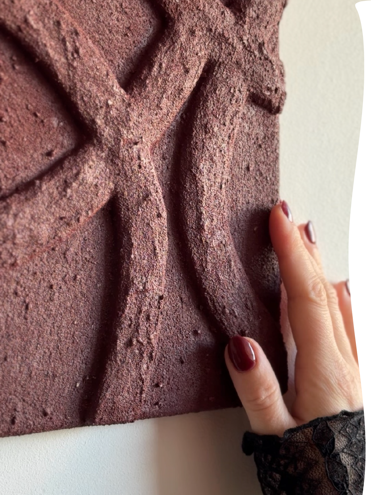 Hand raakt reliëf van Origin Lines Originals kunstwerk in burgundy tint, Studio Lamain