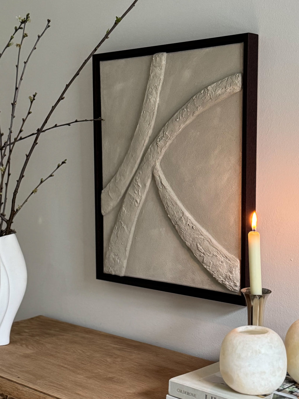 Het 3D textuur wandkunstwerk Origin Lines Narrow & Wide van Studio Lamain in donkere noten lijst in een kalm en neutraal interieur.