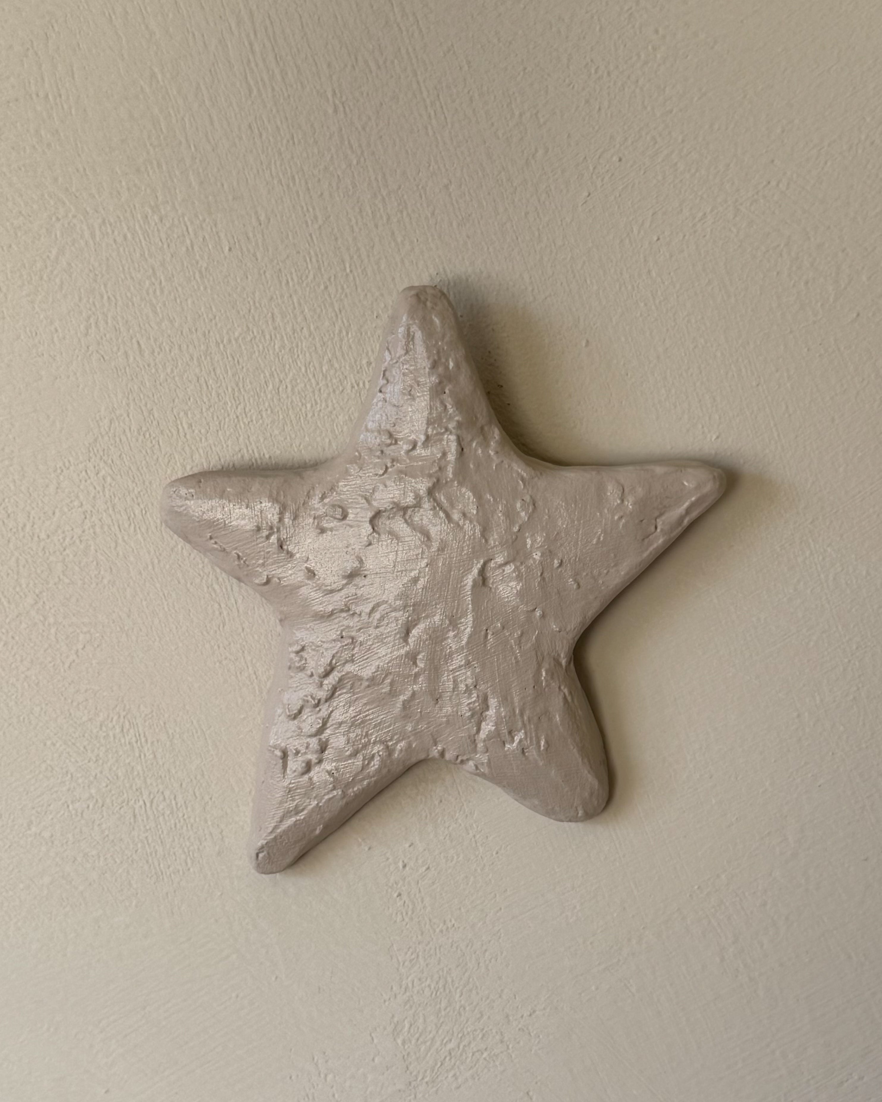 Ster van het To the Moon & Stars wandobject, 3d kunst met structuur in kalkzand kleur op een muur.